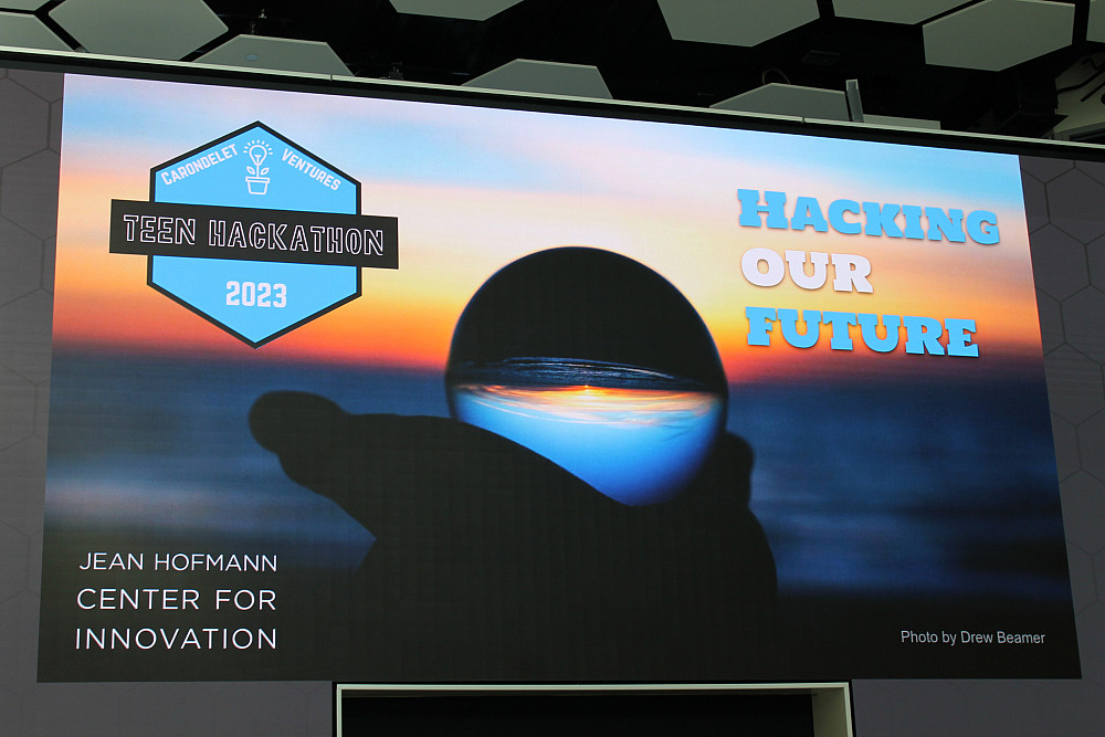    The Jean Hofmann Center for Innovation media wall displays the 2023 Carondelet Teen Hackathon's theme and logo. 