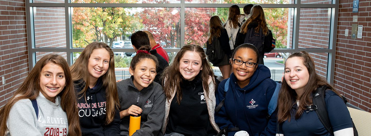 Six students sit with their arms around each other at the Grand Opening of the Jean Hofmann Center for Innovation.