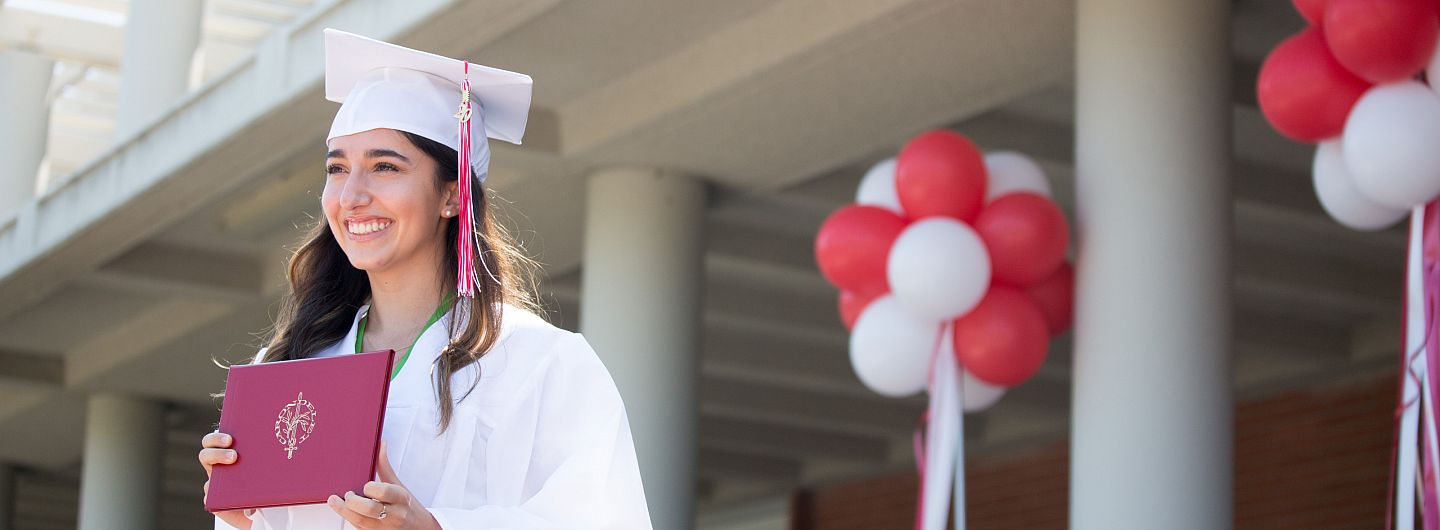 A graduate holds her diploma during the Drive Through Graduation on August 1, 2020.