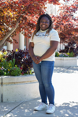 Niala Cole ?21 stands by a tree near the front of campus.