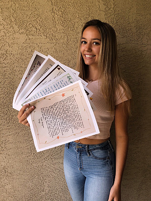 Paige Pearson '21 holds handwritten letters delivered to isolated residents at Mercy Retirement and Care Center.