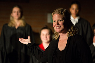 Amy acknowledges the choir at the end of a performance during the Dance and Choir Showcase in May...