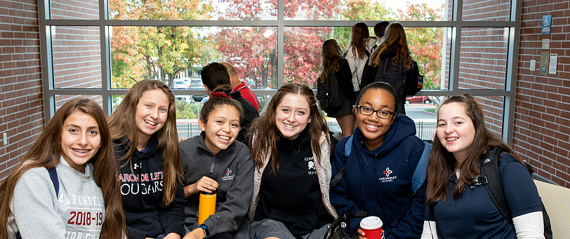 Six students sit with their arms around each other at the Grand Opening of the Jean Hofmann Cente...