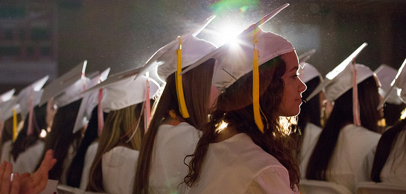 Graduates sit in cap and gown at Commencement 2019.